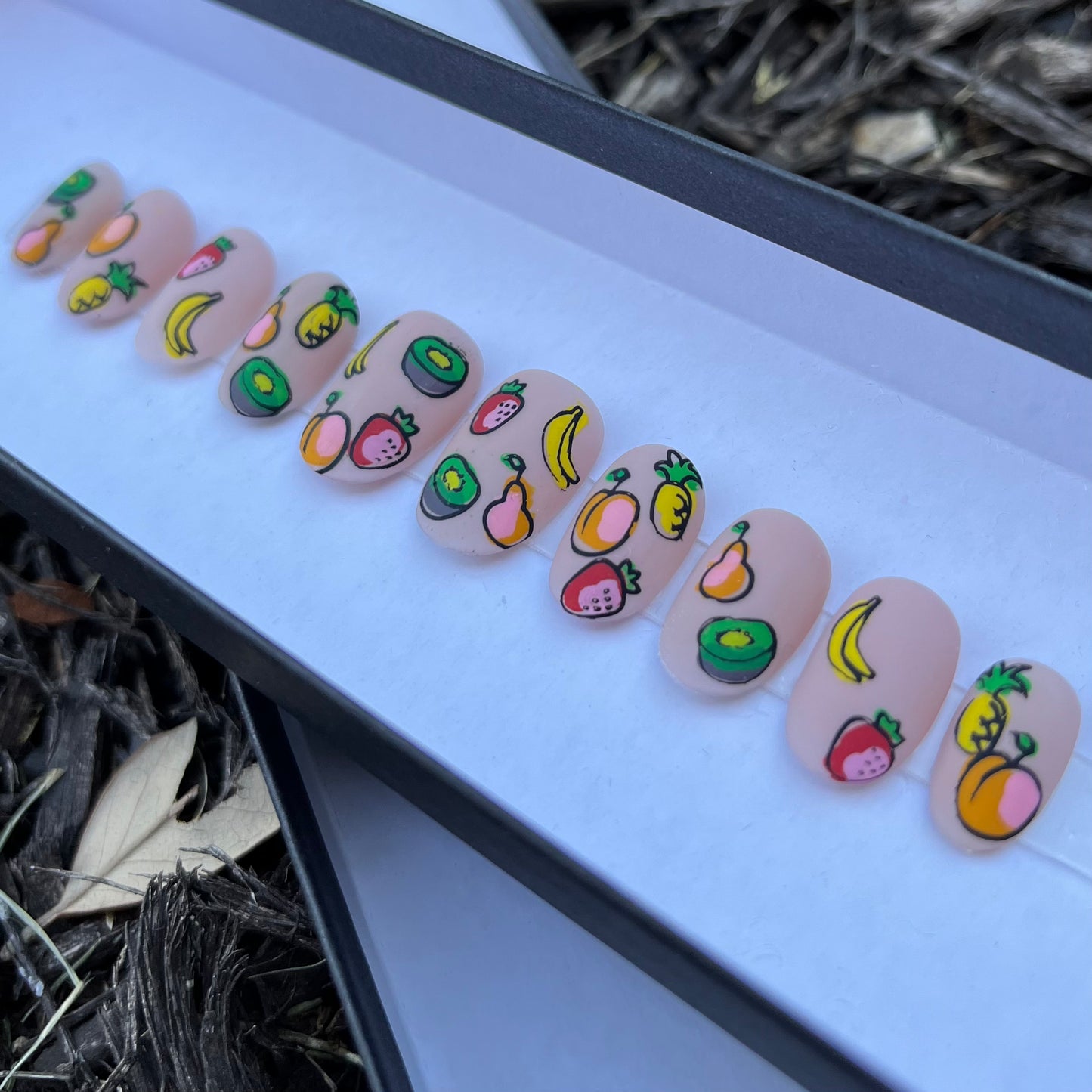 press-on nails with nude background and fruit design